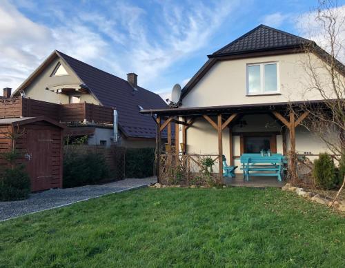 a house with a blue bench in the yard at Dom Tkacki - Apartamenty - Pokoje - Jacuzzi in Kudowa-Zdrój