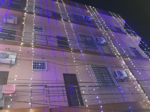 un edificio con luces en el lateral. en K K RENUKA DHARAMSHALA, en Haridwar