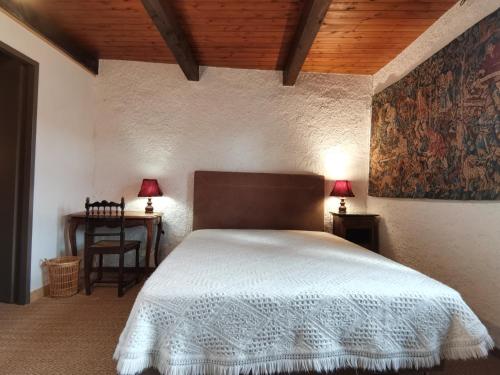 - une chambre avec un lit et une table avec deux lampes dans l'établissement Chez Gilles Math, à Saint-Martin-de-Brômes