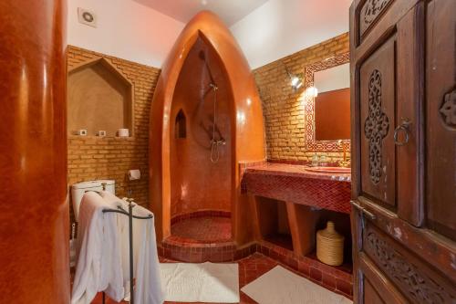 bagno con doccia in legno e lavandino di Riad Amin a Marrakech