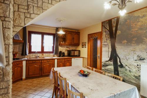 a kitchen with a table and a tree mural on the wall at Maison charmante à Girmont-Val-d'Ajol avec vue sur la montagne in Girmont-Val-dʼAjol