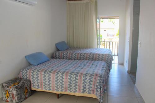 2 camas individuais num quarto com varanda em Solar Água Pipa #260 - Apê na Praia por Carpediem em Pipa