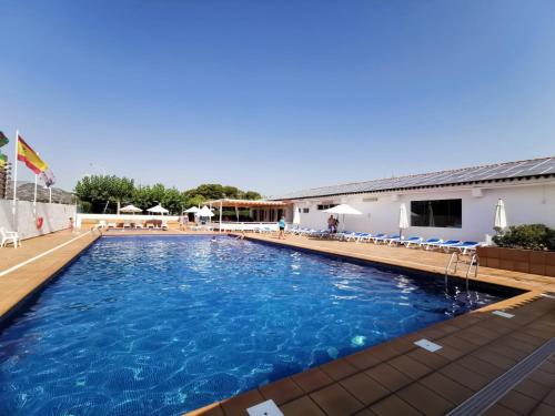 a swimming pool with blue water in a resort at Camping Riberamar in Oropesa del Mar