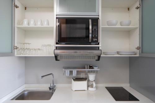 a kitchen with a sink and a microwave at Micro Boutique Living Wolfville in Wolfville