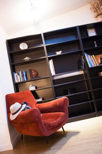 a red chair sitting in front of a book shelf at B&B La Cuntana in Potenza