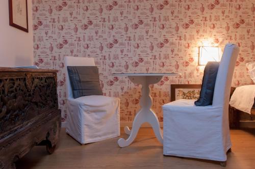 two chairs and a table in a room with a wall at B&B La Cuntana in Potenza