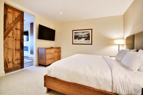a bedroom with a large bed and a television at Modern 1BR Residence in Canyons VillageSki In Out in Park City