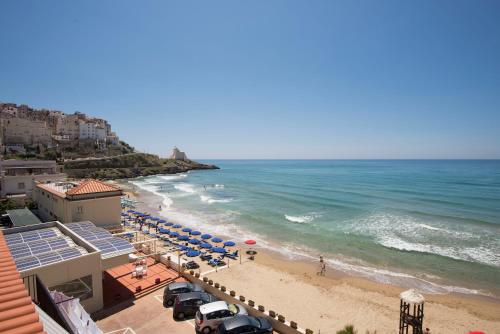 a beach with chairs and umbrellas and the ocean at Albergo La Sirenella in Sperlonga