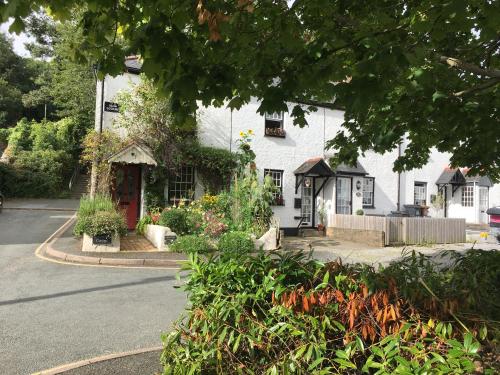 a white house with flowers in front of it at Charming Devon Cottage near Quay-Rain Shower, Restaurants & Free Parking in Kingsbridge