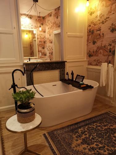 La salle de bains est pourvue d'une baignoire et d'un lavabo. dans l'établissement JARDIN D'HIVER CASSEL Suite de 70 m2, à Cassel