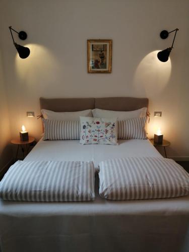 a bed with two pillows in a bedroom with two lamps at Bellagio Holiday Home in Bellagio