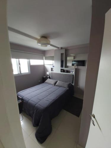 a bedroom with a large blue bed in a room at Hermoso departamento un dormitorio in Santa Fe