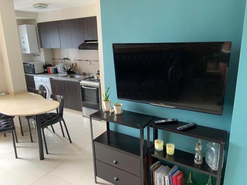 uma cozinha com uma grande televisão de ecrã plano na parede em Hermoso departamento un dormitorio em Santa Fé