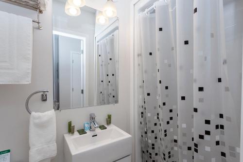 a white bathroom with a sink and a shower at Micro Boutique Living Antigonish in Antigonish
