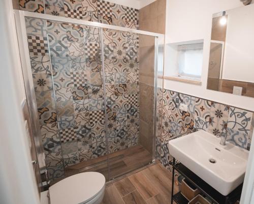 a bathroom with a shower and a toilet and a sink at Le Falesie in Gaeta