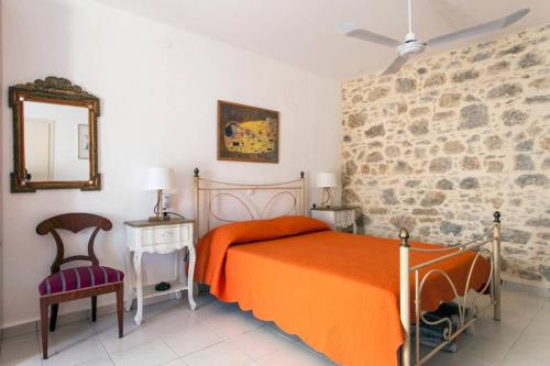 een slaapkamer met een bed, een spiegel en een stoel bij Beautiful Holiday House near the sea in Sissi
