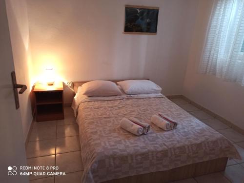 um quarto com uma cama com duas almofadas em Apartment Kosor em Zaboric