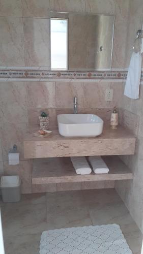 a bathroom with a sink and a mirror at Pousada recantoceccataratas in Foz do Iguaçu