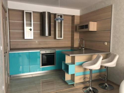 uma cozinha com armários azuis e castanhos e um lavatório em Апартамент Анели em Pomorie