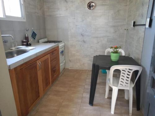 - une cuisine avec une table et deux chaises blanches dans l'établissement La Casa del Molino, à Ramallo