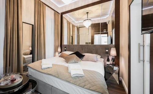 1 dormitorio con 1 cama grande y espejo en Salomea Krakow apartments en Cracovia