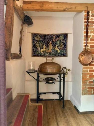 a room with a table with a pot on a wall at Swan Hotel in Harleston