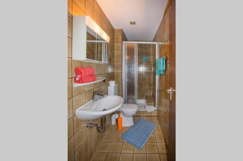 ein Bad mit einem Waschbecken und einem WC in der Unterkunft Ruhiges Gästezimmer am Stadtpark in Schwabach