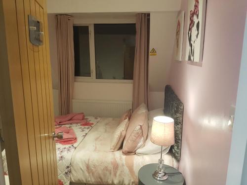 a bedroom with a bed and a table with a lamp at Rosie flanagan's in Skegness