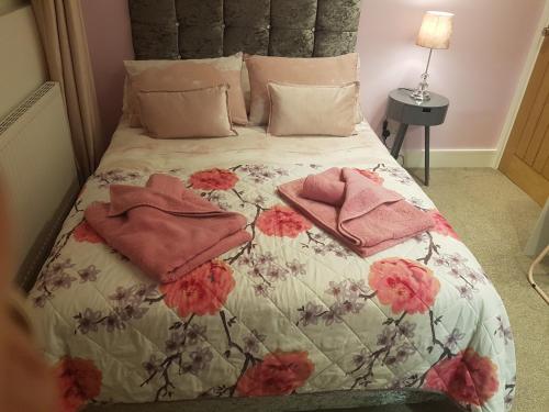 a bed with pink pillows and pink towels on it at Rosie flanagan's in Skegness