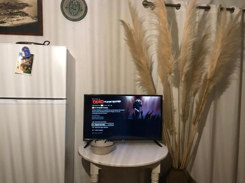 een computermonitor op een tafel naast een koelkast bij Cortijo el Abejaruco in Almuñécar