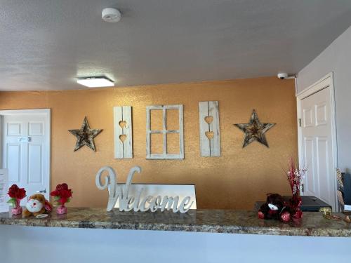 a kitchen counter with stars and a welcome sign on the wall at Hwy 59 Motel Laredo Medical Center in Laredo
