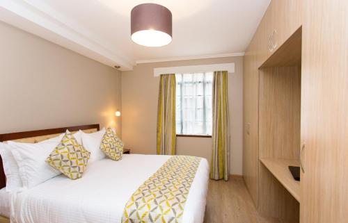 a hotel room with a bed and a window at Cozy Residences by Trianum in Nairobi