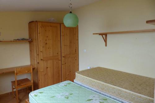 een slaapkamer met een bed en een houten kast bij Calheta - Casa Amarela in Calheta