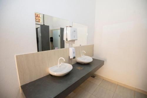 a public bathroom with two sinks on a counter at Canyons Camping Capitolio in Capitólio