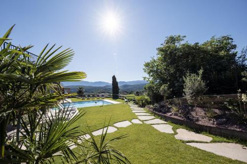 a garden with a swimming pool and a lawn at Hotel Torgglhof in Caldaro