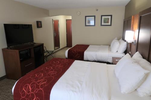 a hotel room with two beds and a television at Comfort Suites Pittsburgh Airport in Coraopolis