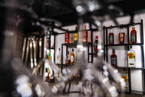 una fila de botellas de alcohol en estanterías en un bar en Rama's Hotel en Tirana