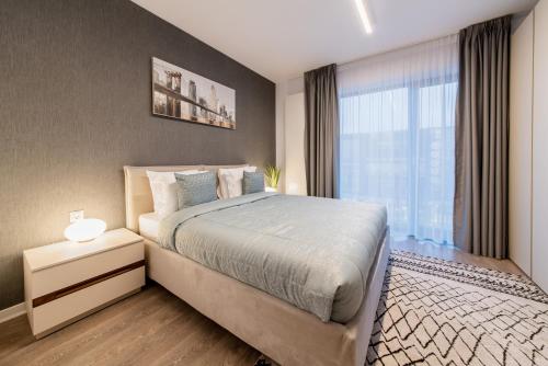 a bedroom with a large bed and a window at NorthAparthotel Bucharest in Bucharest