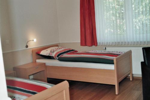 a small bed in a room with a window at Hotel Franke in Alstätte