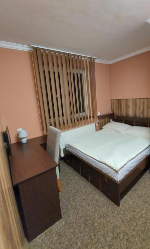 a hotel room with two beds and a desk and a window at Motel Maria in Szałe