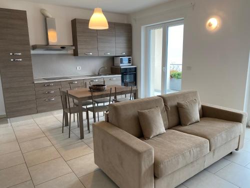 a living room with a couch and a kitchen with a table at Residence Il Poggio in Dorio