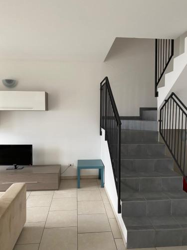 a living room with stairs and a blue bench at Residence Il Poggio in Dorio