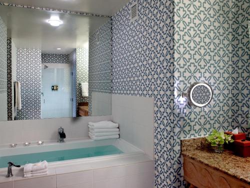 uma casa de banho com uma banheira, um lavatório e um espelho. em Kimpton Hotel Monaco Seattle, an IHG Hotel em Seattle