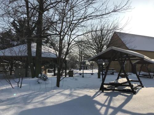 a gazebo in the snow next to a building at Hotel Schöne Aussicht in Weißenfels