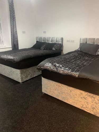 two beds sitting next to each other in a room at Travis House Three Luxury Modern Living free WiFi in Burnley