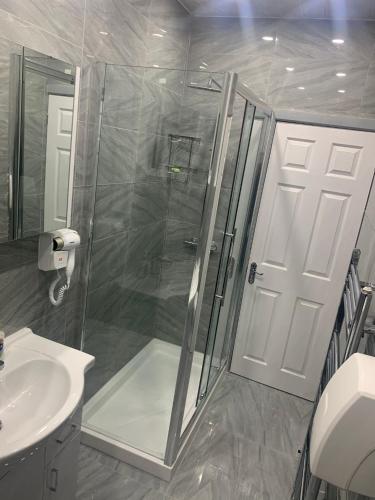 a bathroom with a shower and a toilet and a sink at Travis House Three Luxury Modern Living free WiFi in Burnley