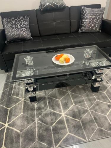 a black couch with a plate of fruit on a coffee table at Travis House Three Luxury Modern Living free WiFi in Burnley