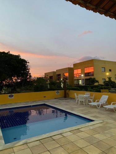 una piscina con sedie e un edificio di flat condomínio paraíso da serra negra - bezerros - PE a Bezerros