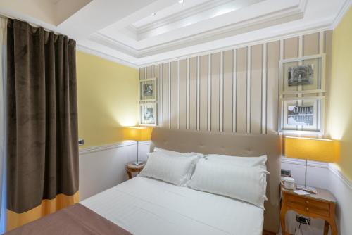 a bedroom with a bed with two lamps and a window at Palazzo Turchini in Naples