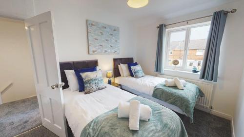 two twin beds in a room with a window at Stunning 3-Bed house in Chester by 53 Degrees Property, ideal for Contractors & Families, FREE Parking - Sleeps 7 in Chester